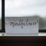 A card with the word mindfulness on it sitting on a window ledge