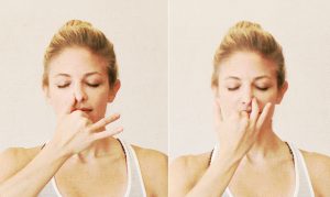 Lady practicing alternate nostril breathing, showing both sides